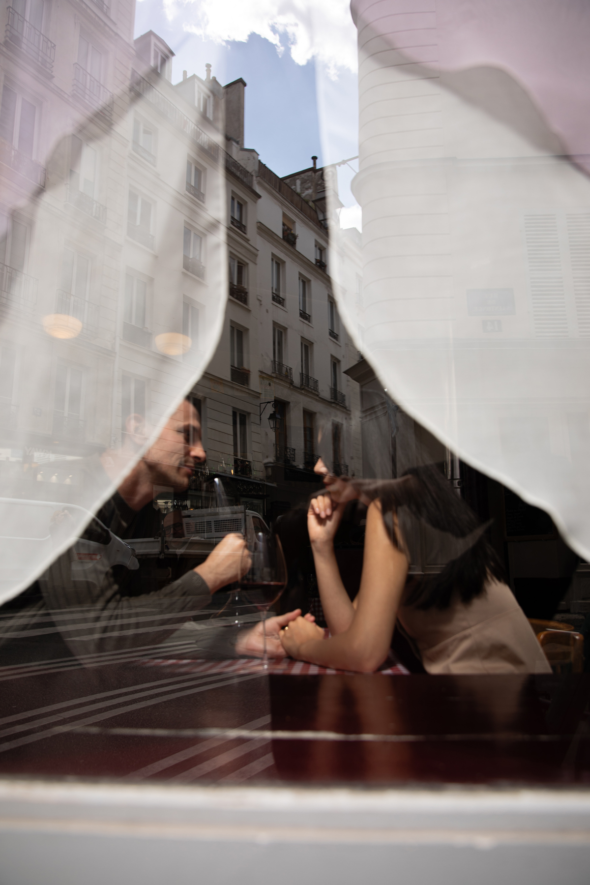 Instant de dégustation de vin observé à travers la vitrine d’un restaurant parisien.