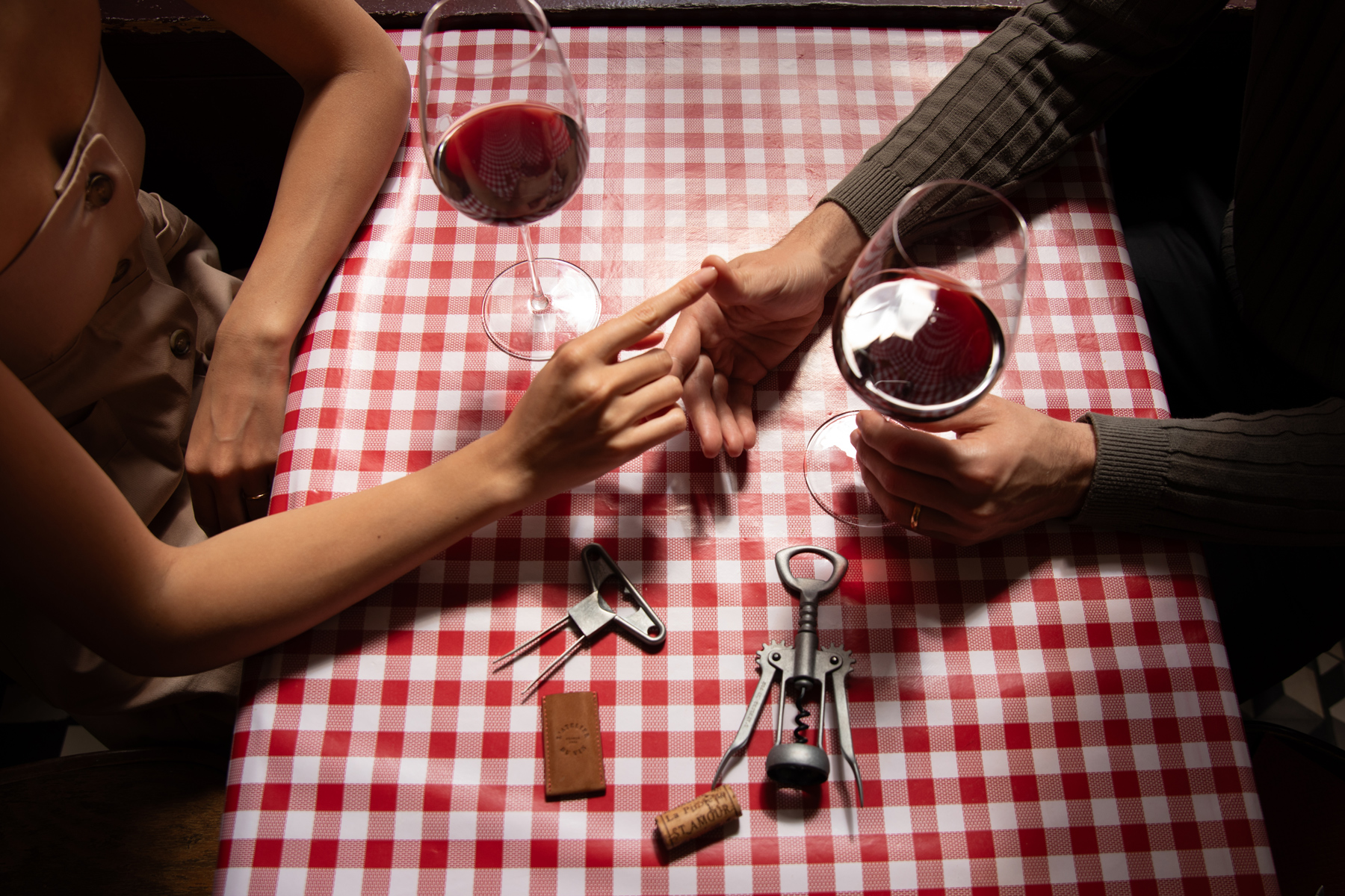 Verres de vin rouge et accessoires de dégustation sur une table de bistrot parisien.