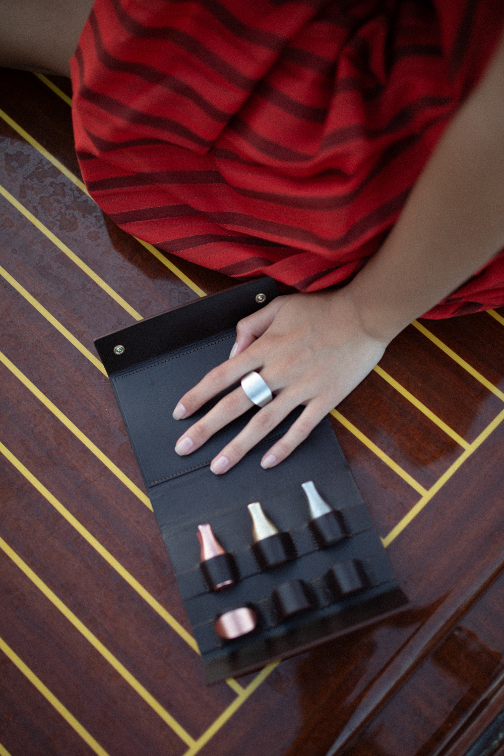 Les six bijoux sont présentés dans une pochette en double cuir de veau ; cuir responsable tanné en Italie. Le cuir extérieur de la pochette est souple, sensuel tandis que le cuir intérieur se fait technique pour éviter les tâches de vin.